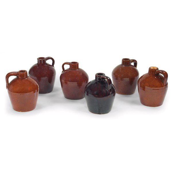 Roycroft syrup jugs, set of six: Roycroft syrup jugs, from the Roycroft Shops, set of six, each with a single handle in varying brown glazes, one with stopper, signed, 4"w x 5"h.From the collection of Dr. Edgar G. McKee.