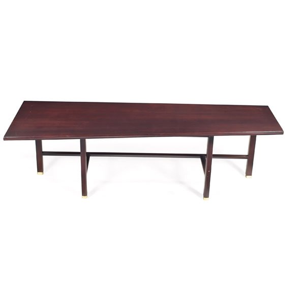 Edward Wormley coffee table, by Dunbar, mahogany: Edward Wormley coffee table, by Dunbar, mahogany, elongated trapezoidal top, offset legs with brass capped feet connected by horizontal stretchers, refinished, signed with rectangular brass tag, 60"w 