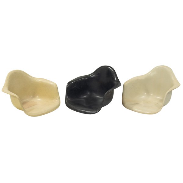Charles & Ray Eames shells, three: Charles & Ray Eames shells, three, by Herman Miller, no bases, molded fiberglass, one yellow, one black, one parchment, one missing shock mount, original finish, signed with Herman Miller marks, 25"w