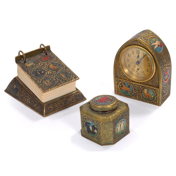 Tiffany Studios desk items calendar base: #1093 inkwell: Tiffany Studios desk items, bronze in the Zodiac pattern, colorfully enameled, calendar base: #1093, 6"w x 4"h, inkwell: #1077, 3"w x 3"h, clock: #1075, 4"w x 5.5"h, all with an original gold dore pat