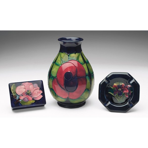 Moorcroft box Moorcroft vase Sally Tuffin Moorcroft ash: Moorcroft box, magnolia design on dark blue, 4"w x 1.5"h; with a Moorcroft vase, c. 1988, Sally Tuffin rose design on dark blue, signed J. Moorcroft, 21-5-91, initials WM, 5.5"w x 7.5"h; with a Moorcr