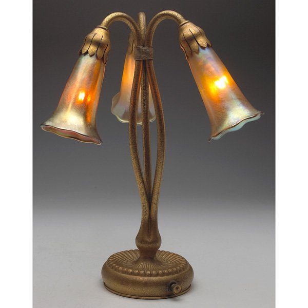 Tiffany Studios lily lamp bronze dore: Tiffany Studios lamp, three-light lily, bronze base with an original gold dore patina, holding 3 well matched gold glass shades with a nice overall iridescence, base signed Tiffany Studios, New York, 