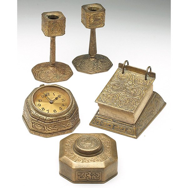 Tiffany Studios desk items: Tiffany Studios desk items, clock, #1076, 3"h; candlesticks, pair, #1206, 6"h inkwell, #842, 4.5"w; calendar stand, #1093, 4"h, all bronze in the Zodiac pattern, all with an original gold dore patina,
