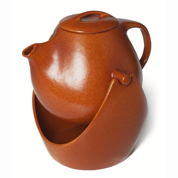 Roseville Raymor coffee pot, swinging form: RV Raymor coffee pot, unusual swinging form covered in a brown matt glaze, marked, original caution label, 9.5"w x 8.5"h. The overall height is 12" with stand