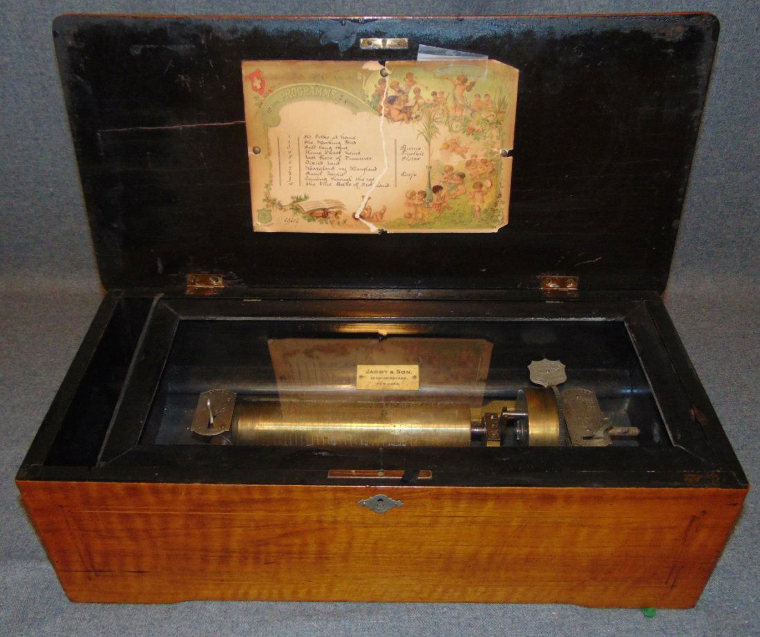 Antique Mermod Freres Swiss Cylinder Music Box: Antique Mermod Freres Swiss Cylinder Table Top Music Box by Jacot & Sons, New York. 10 tunes. Inlaid mahogany case. Measures 19-1/2" wide x 9-1/4" deep 6-1/2" tall. Overall condition is fair to good w
