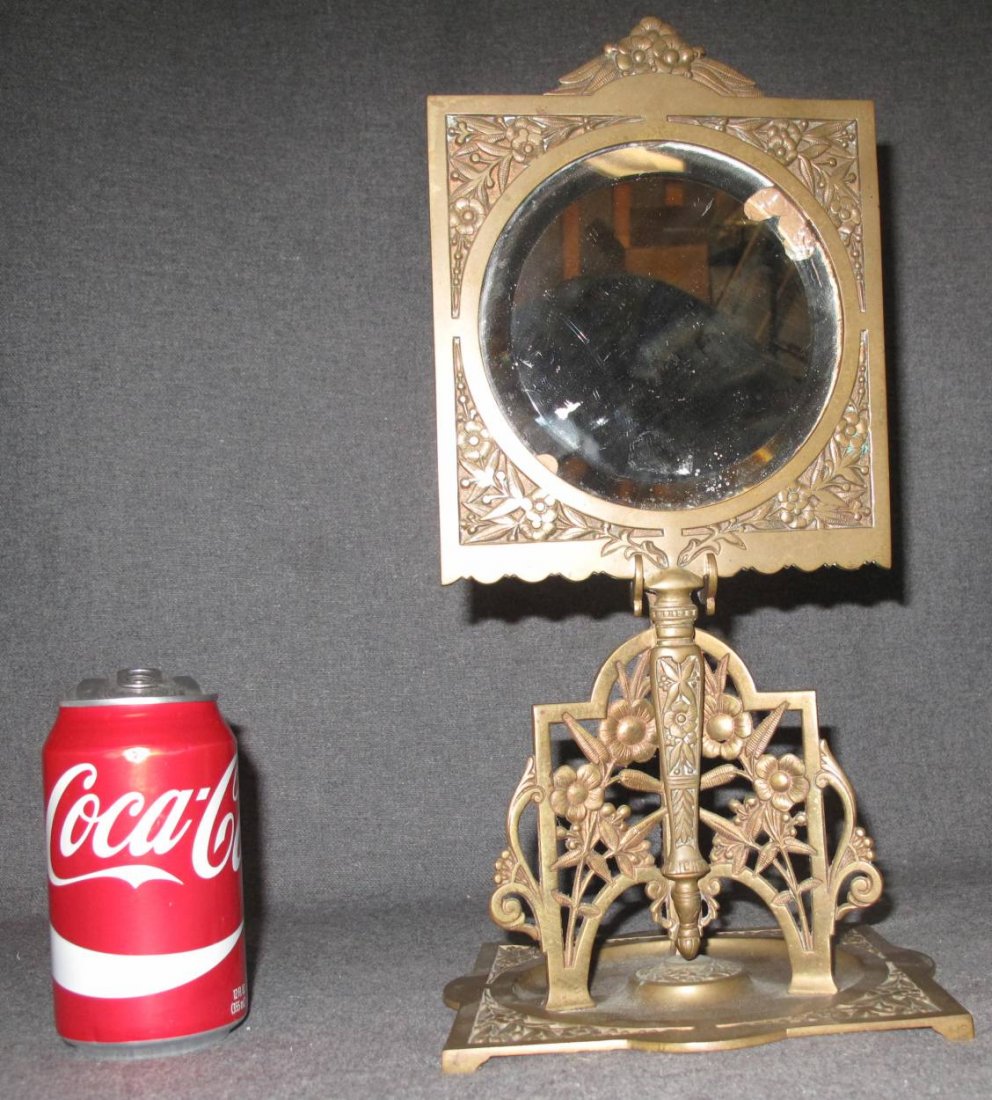Antique Victorian Brass Vanity Mirror on Stand: Antique Victorian Brass Vanity Hand Mirror on a Stand. Measures 13-1/2" tall x 6-1/2" wide. Base is 7" x 7" wide. Overall condition is good. No damage. Original Beveled mirror has a chip. Several Ship
