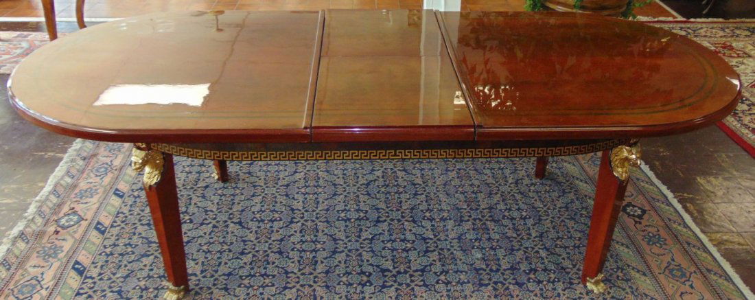 Elegant Versace Style Oval Dining Table: Versace Style Oval Dining Table with Bronze Mounts & Feet. Like New Condition. Beautiful Greek Key Design. Butterfly leaves recess inside when not in use. Measures 32" tall x 88" wide x 46" deep befor