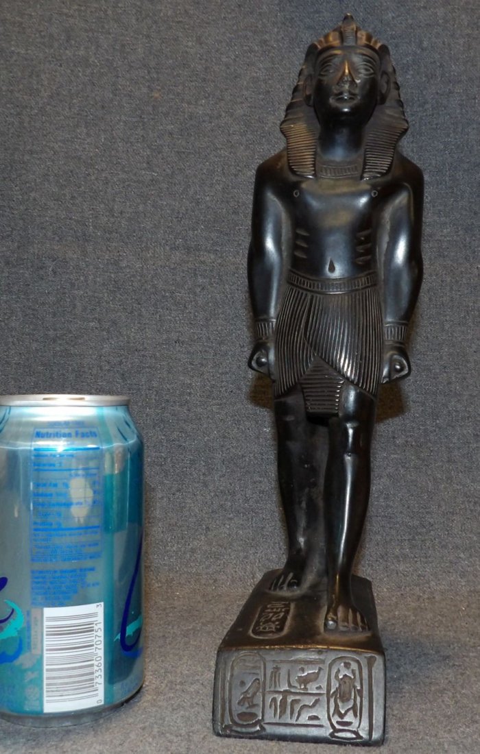 EGYPTIAN PHARAOH BASALT POLYSTONE SCULPTURE: Egyptian Pharaoh Black Basalt Polystone Sculpture. Measures 12" tall x 2-1/2" wide x 5-1/2" deep. Condition is good. Some wear to finish. Small chip on nose. Starting Bid $20. Auction Estimate $40 - $