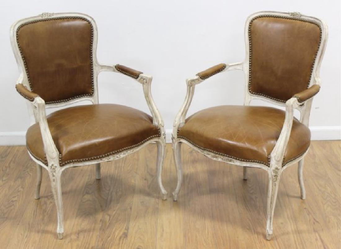 Pair Louis XV Style Country French Fauteuils: Leather seat and back. Off-white finish. Brown leather. Country French. Thumbtacked trim. Approx. 34" H (back) x 22" D arm to arm. Good condition.