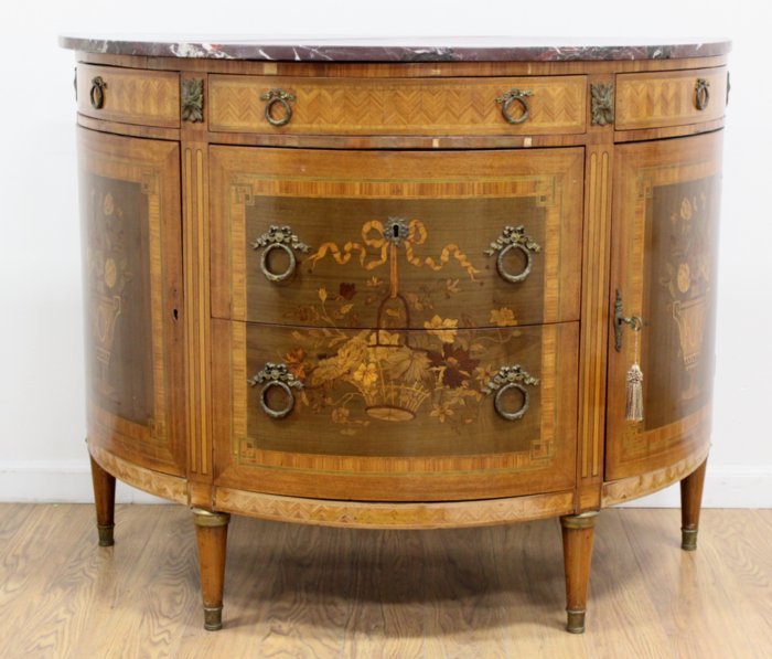 1920s French Inlaid Demilune Commode: Approx. 36" H x 44" L x 21" W. Chips to veneer. Repaired marble.