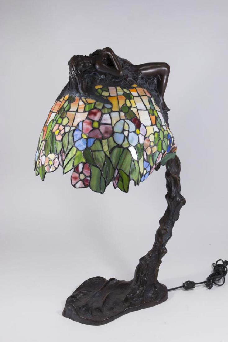Leaded Glass Art Nouveau Style Bronze Table Lamp: Contemporary. Signed on base E. Thomasson. Floral design with female nude reclining over shade. Approx. 28 1/2" H. Cracks on 3 glass pieces.