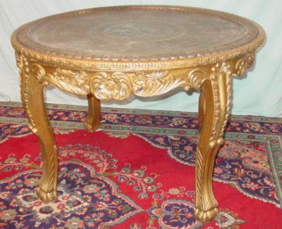EGYPTIAN GILT WOOD CENTER TABLE: FURNITURE. EGYPTIAN GILT WOOD CENTER TABLE WITH BRASS TOP CA. 1940'S APPROX. 50" ROUND X 33" H