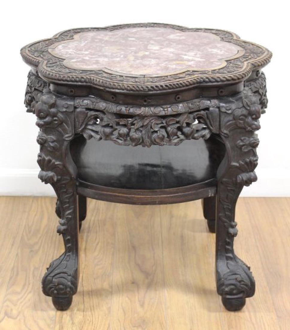 Carved Chinese Teakwood Table: With rouge inset marble scalloped edge and floral carving. Approx. 22" H x 22" diameter. Property from the collection of Hank Willoughby, Allenwood, NJ. Minor surface scratches on marble, otherwise go