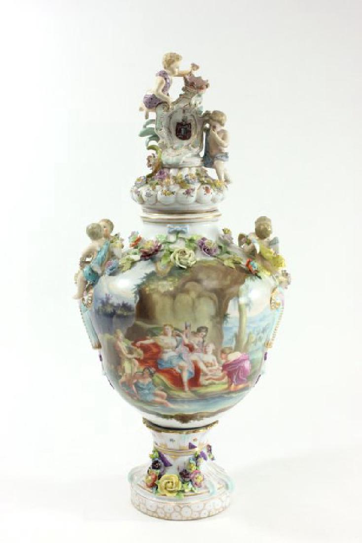 German Porcelain Urn with Muses Scene on Front: Decorated with cherubs and flowers. Marked on bottom for Carl Tielsch. Approx. 24"H with cover. Restorations to body and cover..