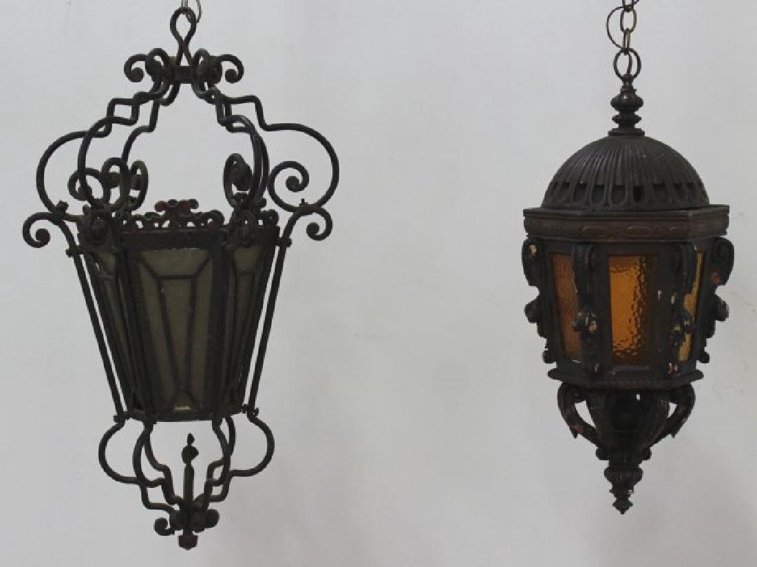 2 Lanterns: One wood with amber glass, approx. 12" x 11"; and one wrought iron, approx. 29 1/2" x 18". Wood lantern missing one glass.