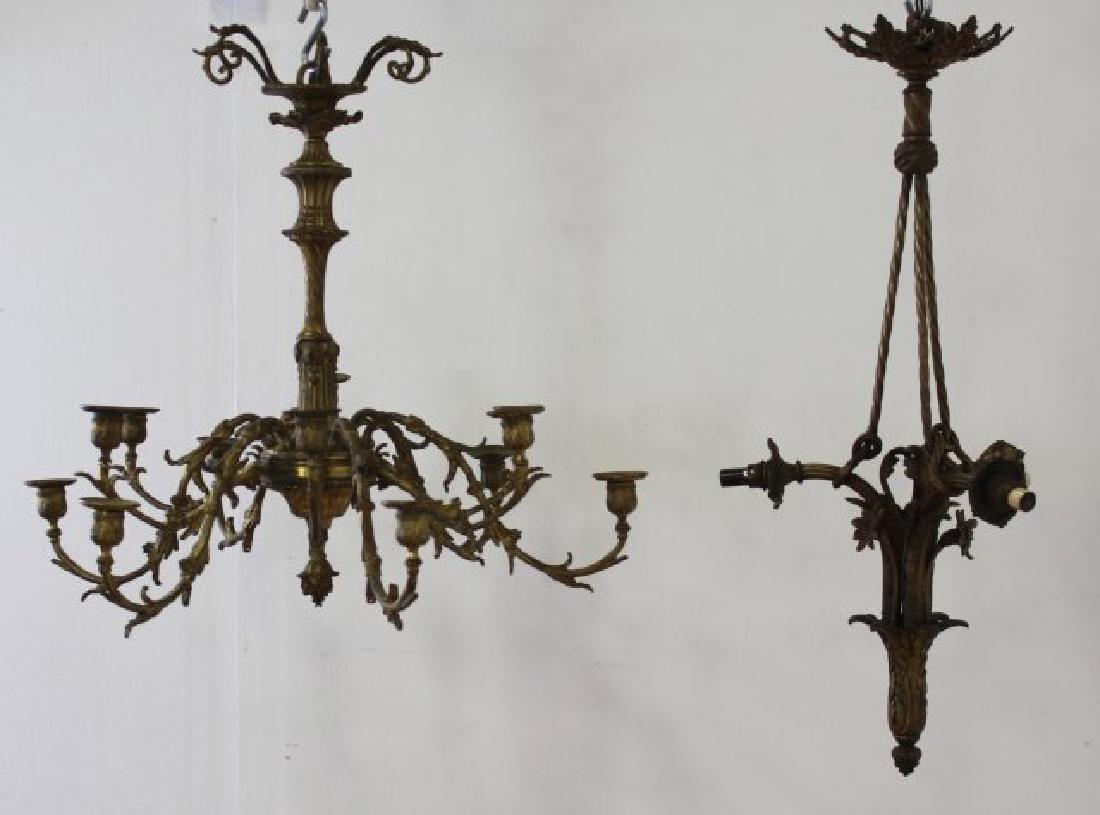 2 Continental Neoclassic Style Brass Chandeliers: Approx. 22 1/2" H x 24" diameter and 28 1/4" H x 11 1/2" diameter.