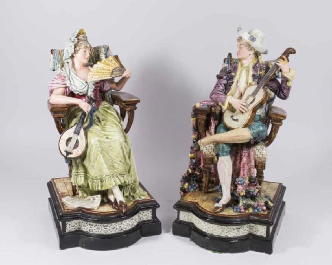 :Pair Majolica Seated Figures: Woman with fan, man with guitar. Approx. 15 1/2" H. (6183) Both with minor losses and restorations.