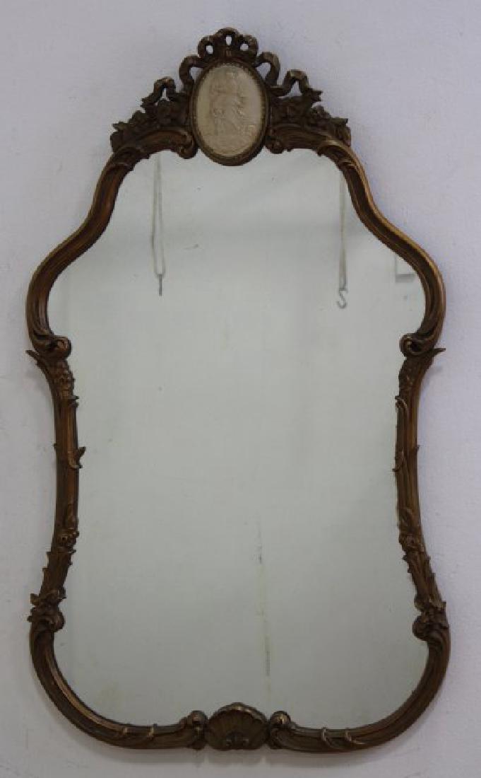 Giltwood Scroll Design Mirror: Circa 1930s. With angel and cupid. Approx. 44" H x 25 1/2" W.
