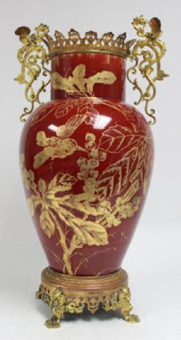 :Bronze & Enameled Handpainted Porcelain Urn: Griffin handles. Red with gold highlights. Chinese motif. Approx. 31" H.