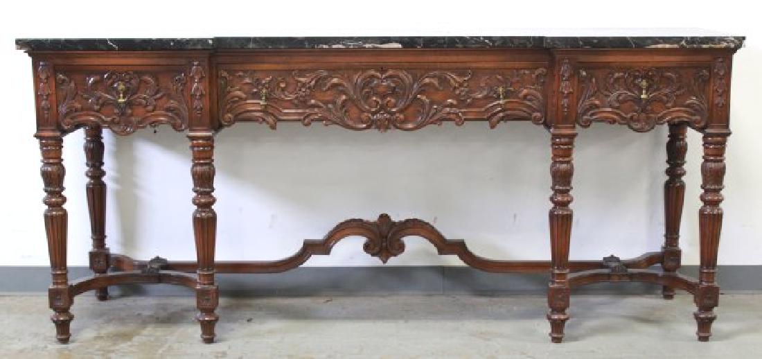 Circa 1920s Marble Top Carved Walnut Sideboard: Floral and scroll design. Black marble. Approx. 36" H x 82" L x 22" D. Small chip corner of marble front right.
