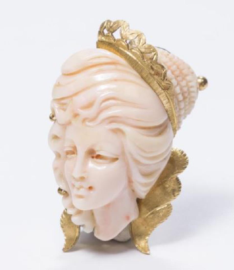 :18K Gold & Carved Coral Brooch: Depicting female bust wearing crown. Approx. 1 7/8" H x 1 1/8" W.