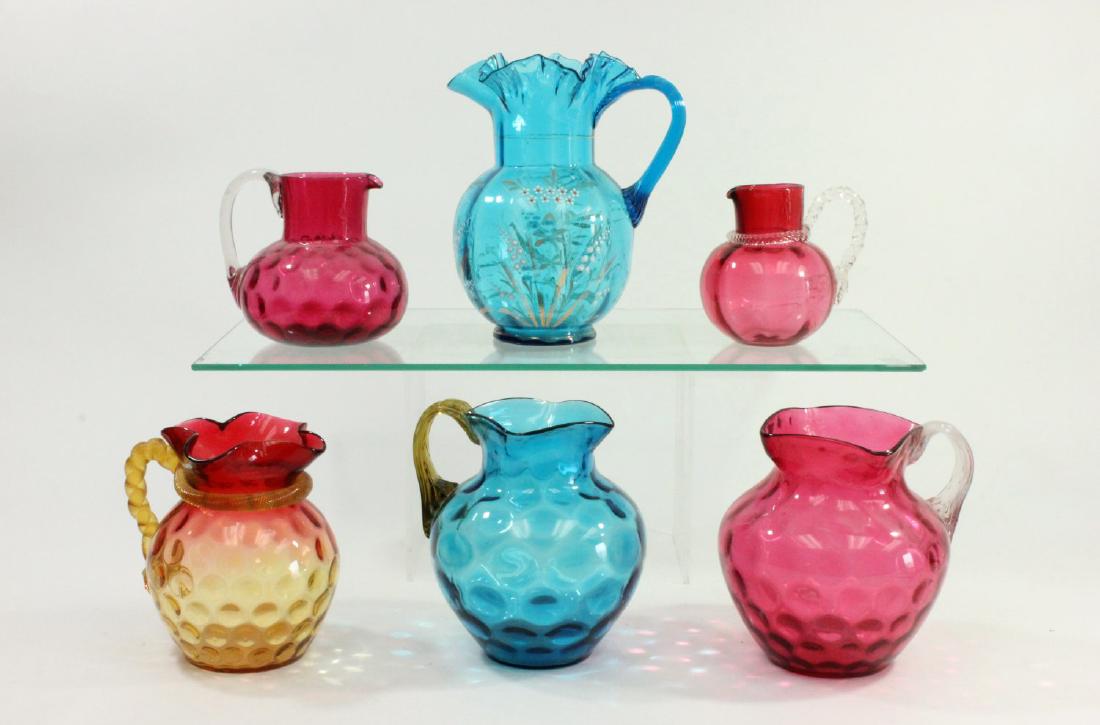 Lot of 6 Victorian Glass Pitchers: Including amberina glass, cranberry glass, and blue enamel decorated. Various sizes. Tallest approx. 10" H. From a Yonkers, NY estate.