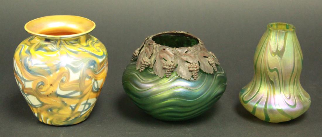 Lot of 3 Art Glass Vases: Including Quezal, approx. 4 7/8"; unsigned possibly Loetz vase, approx. 4 5/8" H; and possibly unsigned Loetz vase with brass wine motif collar, approx. 3 3/4" H. From the personal collection of Jeffr