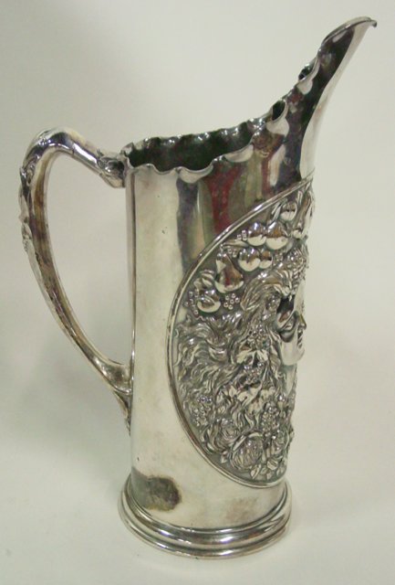19th c. James Tutts silver plate pitcher: Depicting Art Nouveau scene "Woman with Cherub". Dent on bottom. Approx. 9.75" H x 6.75" W (handle to handle). From the Palmetto Estate of Dorothy Martin.