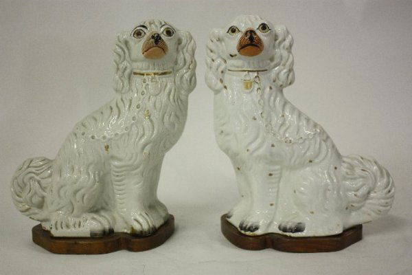 Pair Staffordshire dogs on wood stands: Approx. 13" h. From the estate of Seymour "Cy" Leslie, founder of MGM/UA Home Entertainment.