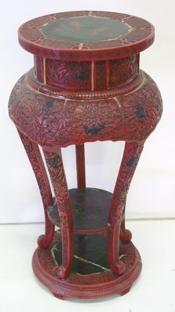 Antique Chinese lacquered carved pedestal: Possibly cinnabar. Carved with black on red designs. Repaired. Top insert needs repair. Has been poorly repaired in numerous spots. As is condition. Approx. 30.5" H