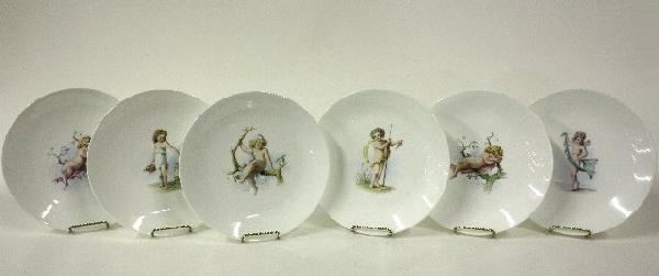 Set of 6 handpainted porcelain Minton plates: Depicting "Cherubs". One plate has line. Signed by various artists. Approx. 9.5" Diam.