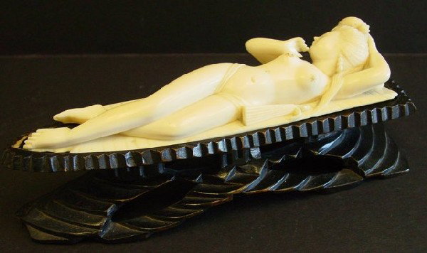 Far Eastern erotic ivory "Nude Woman Lying Down". : Ivory nude on teakwood stand 1" Piece chipped off bamboo leaf underneath her feet, chip on bamboo leaf under her left elbow. Figure Approx. 6.25" L