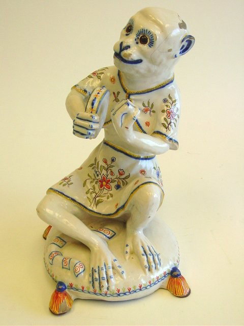 Continental Majolica "Monkey with Tambourine" : Crack in glaze on face. Chip on head and tassel foot. Approx. 15.5" H. From the Estate & Collection of Eric Schmidling.