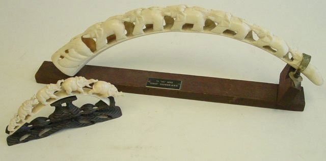 2 African tusk carvings on stands: 1-19.5" W. 1-8" W depicting "Train of Elephants". Contents of the Brooklyn Heights Montague Terrace estate of J. Victor Herd & his wife Pauline Hoffman Herd