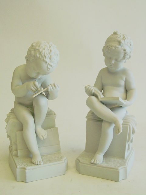 Pair antique European Parian figures: "Cupids". Each signed on back "CW with Crown". Approx. 12" H
