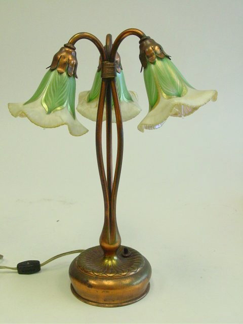 Tiffany Studios three light "Lilly" lamp: With three Quezal shades, one shade cracked under base.
