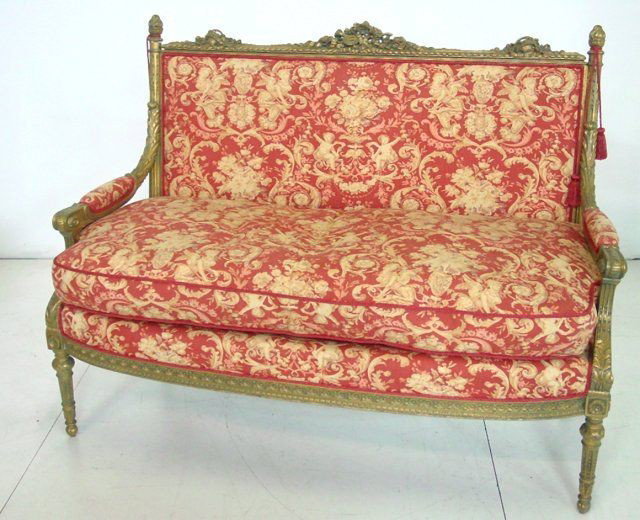 Louis XVI carved giltwood settee: Rose & beige scenic upholstery depicting caryatids & cherubim, down cushion. Approx. 42" H (back) x 56" W (arm to arm).