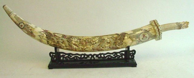 Contemporary carved Chinese buffalo bone sword: On wood stand depicting "Dragons". Approx. 56".