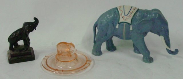 Group lot 3 elephants: Includes:1-5.5" H iron elephant doorstop painted black, 1-7.25" H x 12" W porcelain elephant made in Spain (chip on toe) & 1-pink depression glass elephant ashtray.