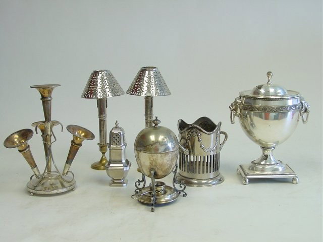 Group lot of silver plate: Including: Egg warmer, epergne, sugar shaker, champagne bucket, pair candlestick holders & covered tureen with "Lion" handles. Please read our terms of sale.