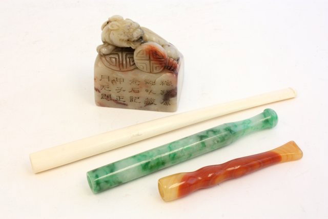 Lot of 4 Chinese items: Including: 1- Soapstone figural stamp, approx. 2.75" H. 1- Ivory pipe, approx. 7" L. 1- Jade pipe, approx. 4.75" L. 1- Agate pipe, approx. 3.25". Please read our terms of sale.