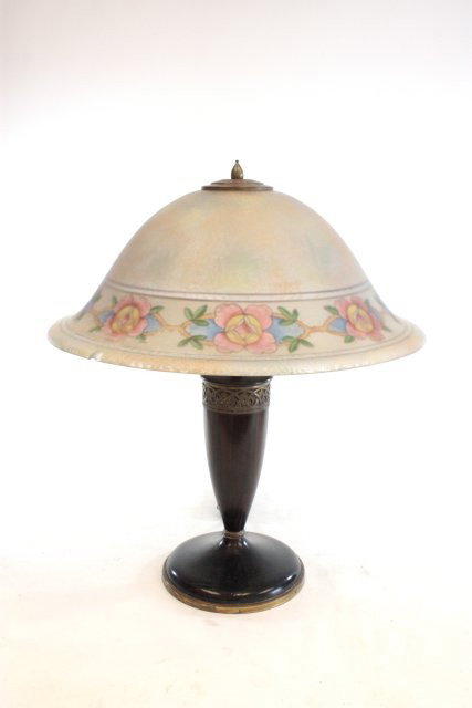 Pairpoint reverse floral painted glass shade lamp: Table lamp, signed, 3 chips on rim. Approx. 17.75" x 8" dome, 21" x 7" bronze & wood base. Please read our terms of sale.