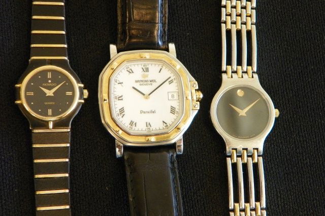Lot of 3 watches- 1 men's 2 ladies: 1- Men's Raymond Weil watch with black leather band,quartz. 1- Ladies Movado watch- black & gold tone, quartz. 1- Ladies Movado watch- white & yellow metal bracelet. Please read our terms of sale.