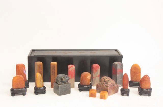 16 Chinese pieces in Zitan wood box: Including: 2- Stamps with carved Foo Dogs. 3- Chicken blood stamps. 7- Soapstones. 4- Soapstones. 7- Wood stands. Various sizes. Please read our terms of sale.