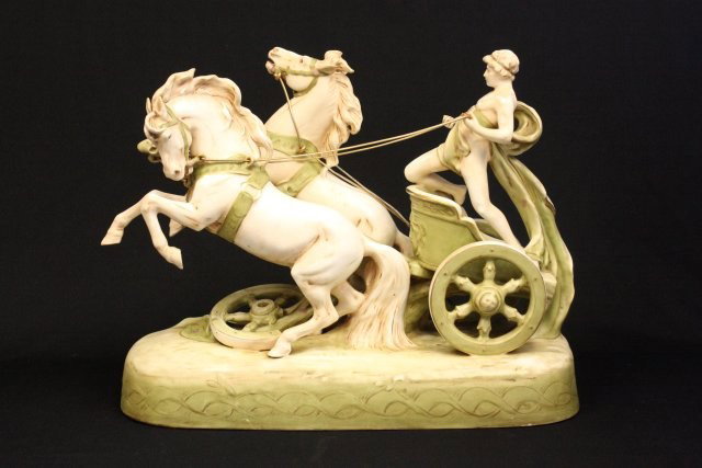 Attributed Royal Dux Greek "Chariot & Horses": Ceramic sculpture. Ca. 1920. Approx. 22" L x 17" H x 10" D. Repair to one leg, minor chips. Please read our terms of sale.