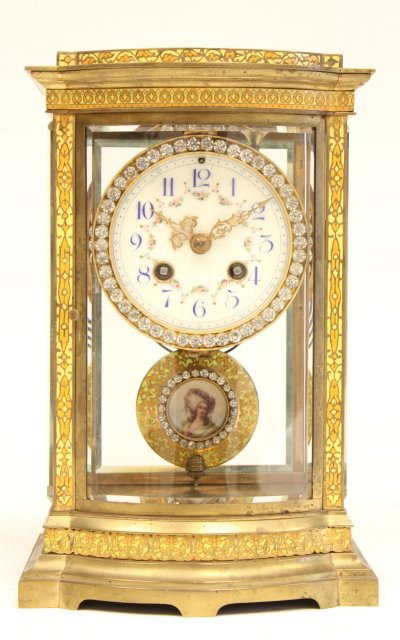 Enameled crystal regulator clock: Jeweled bezel & pendulum, pendulum has hand painted "Lady" in center, curved glass front, enameled all around, with key. Approx. 11" H x 7" W x 6" D. Please read our terms of sale.