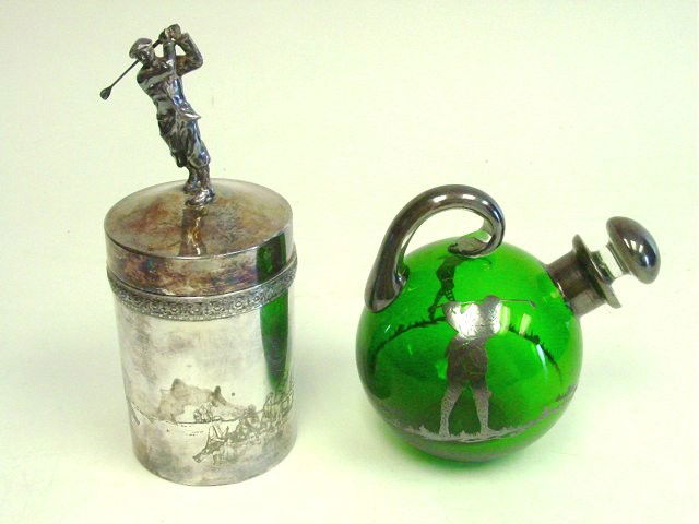 2 pieces golf memorabilia: Including: Green glass pitcher with silver overlay of a golfer, approx. 7" H. Silver plate humidor with golfer on top, with relief etched golf scene, approx. 10" H. From a Summit, NJ estate. Please re