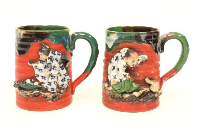 2 Japanese signed figural cups: Chip on 1 hand. Approx. 5.25" H. From a Darien, CT estate. Please read our terms of sale.