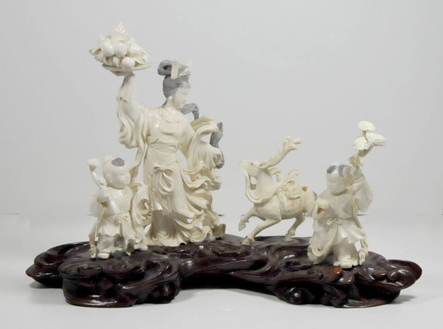 Chinese carved ivory on rosewood base: Depicting "Goddess of Fecundity", bearing tray of peaches, two attendants holding scepters, lotus plant & unicorn (creature of good omens, longevity & grandeur). Approx. 7" H x 9" Please read our term