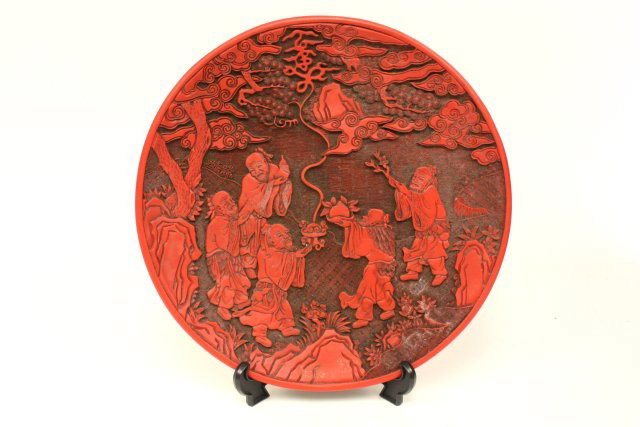 Large red Chinese cinnabar charger: Depicting carvings of "Men Holding Offerings". Approx. 14.25" Diam x 1.5" H. Please read our terms of sale.